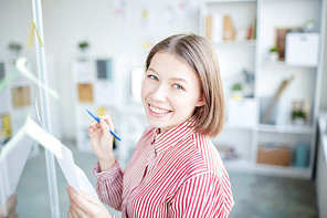 Portrait of smiling businesswoman planning work on an adhesive notes at office