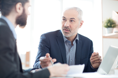 Mature businessman discussing contract with his coworker at office