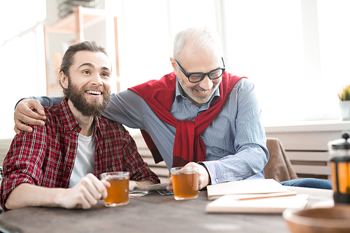 Two business colleagues drinking tea and laughing during a meeting