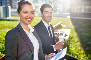 cheerful businesswoman in formalwear  while having meeting with colleague in urban  on sunny day