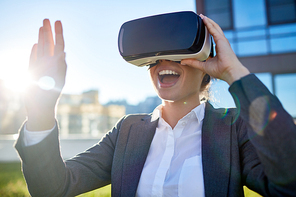 Excited businessman with vr headset found herself in imaginary world outdoors