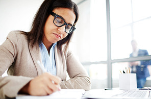 Serious woman making notes in her notepad