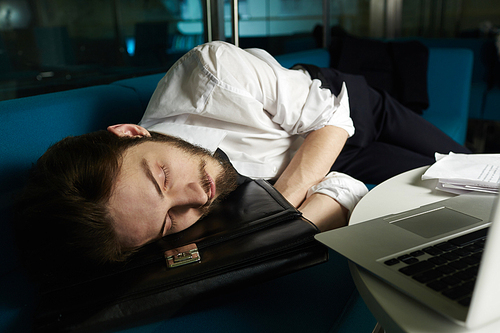 Overworked ceo sleeping by his workplace in office