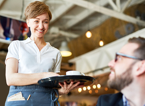 Young servant bringing drink for customer