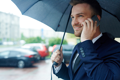 Successful leader making appointment on the phone on rainy day