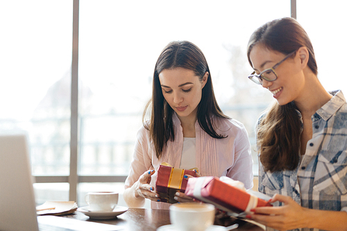 Serious businesswomen with packed gift-boxes