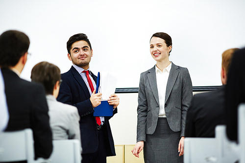 Successful businessman introducing his co-worker to audience who is going to make report upon the topic of seminar