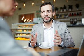 Portrait of mature businessman businesswoman meeting with partner in cafe discussing work and gesturing actively