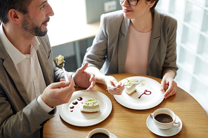 Modern entrepreneurs discussing their business by dessert in cafe