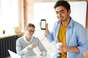 Young man with drink showing online advert of takeout coffee-shop