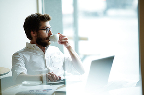 Businessman drinking coffee while thinking of new project