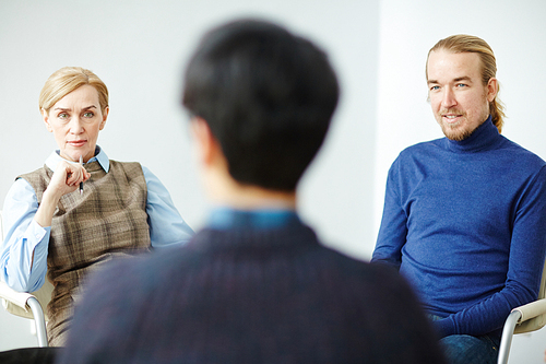 Young man and mature woman listening to story of patient