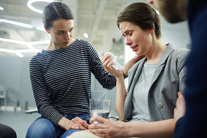 Crying woman telling her problem while compassionate friends listening to her