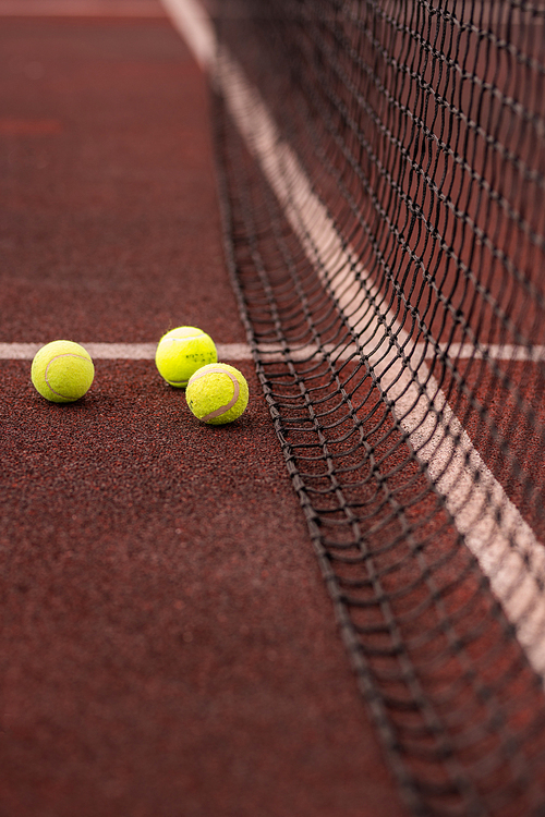 Group of yellow tennis for tennis game by net on stadium playground or court