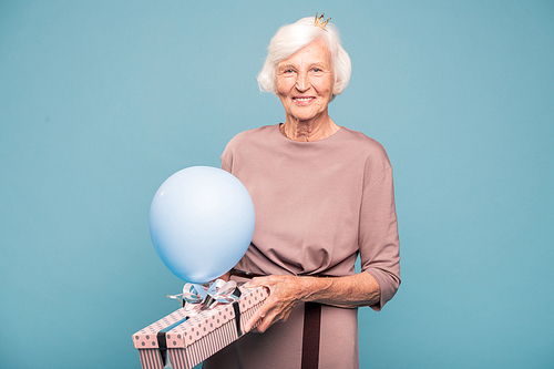 Happy elegant mature woman with balloon and giftbox congratulating you on holiday