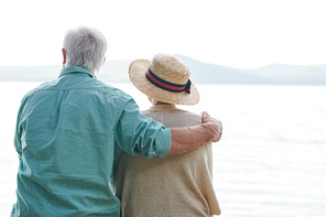 Peaceful and romantic senior couple in casualwear spending time by seaside and enjoying weather and the day