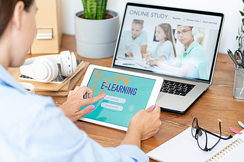 Young woman using digital tablet to sign in online educational site while learning by desk at home