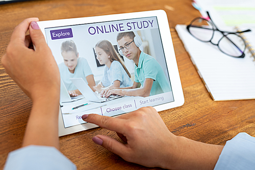 Young woman pressing button on touchpad display to register on educational website and choose course of study