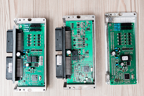 Overview of three demounted gadgets on wooden table ready to be examined by master of repair service