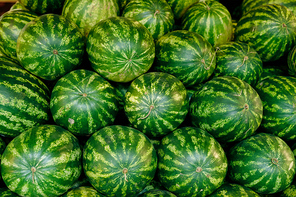 Pile of big ripe green watermelons in supermarket that can be used as background