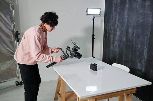 young contemporary video Vlog with camera shooting new photo equipment on desk in studio