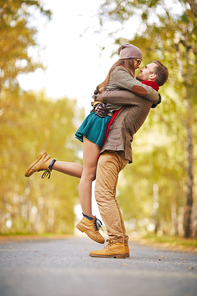 Happy dates embracing in the middle of road in park