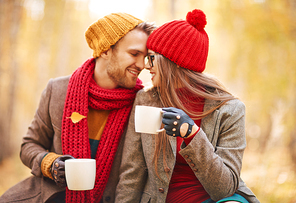 Romantic couple with cups drinking tea outdoors