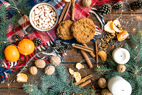 Christmas background with hot drink, cookies and other traditional food and symbols on wooden table