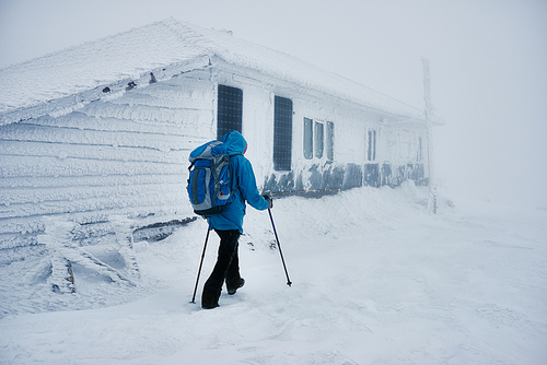 Hiker passing snowy building