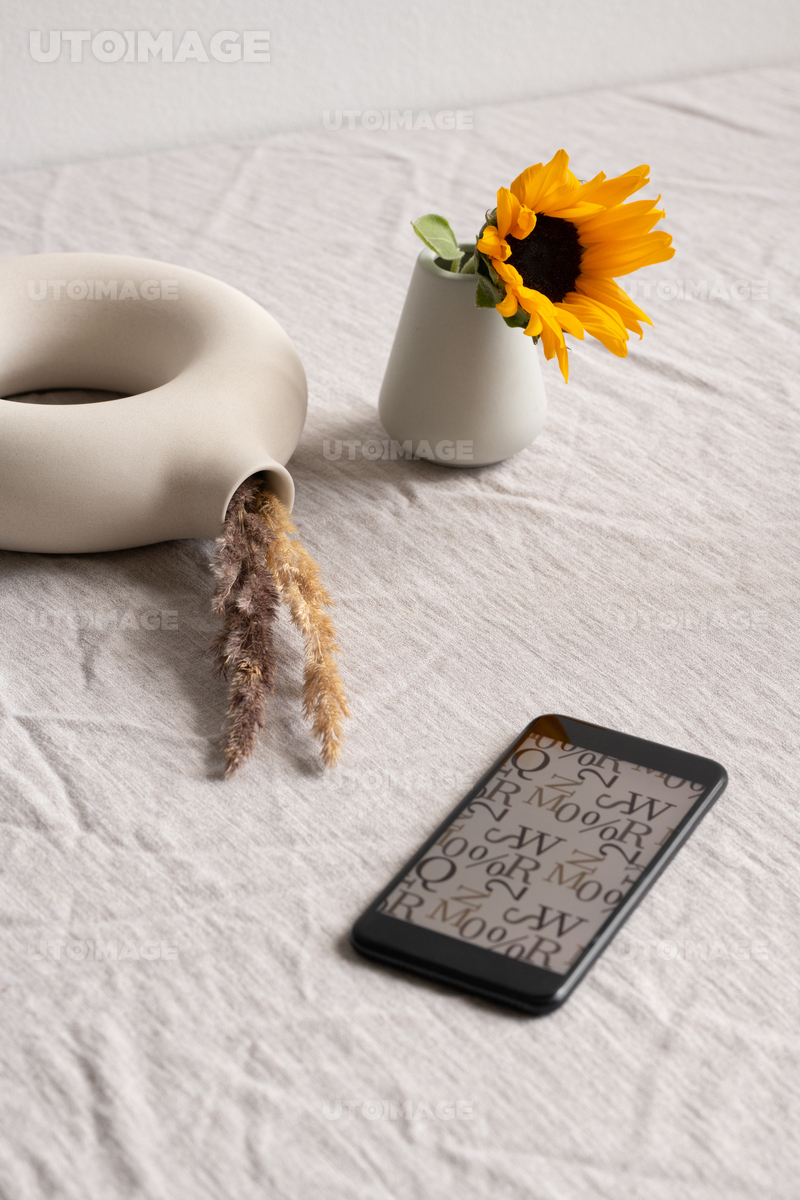 Dried wildflowers in grey clay or ceramic vase standing on table