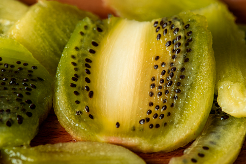 Macro image of cut fresh kiwi with black seeds ready to eat, to be put into fruit salad or smoothie or be used for making provisions