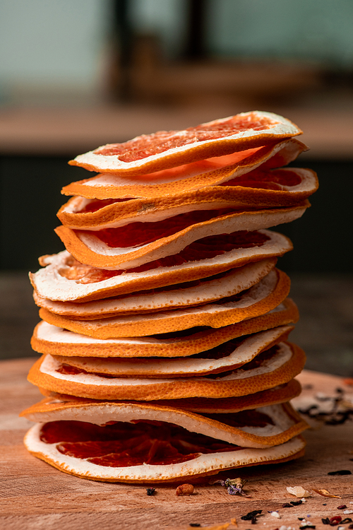Stack of sliced fresh grapefruit on wooden board ready to be put in fruit dryer