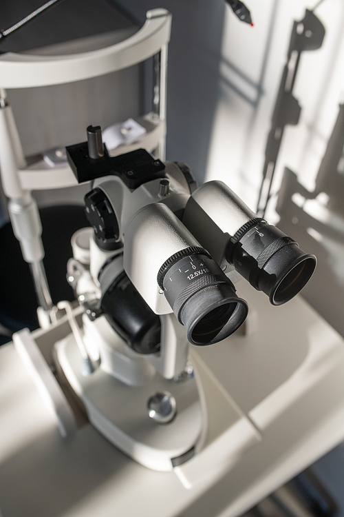 Oculars with lens of ophthalmological diagnostic equipment on doctor workplace inside medical office of contemporary ophthalmic clinics
