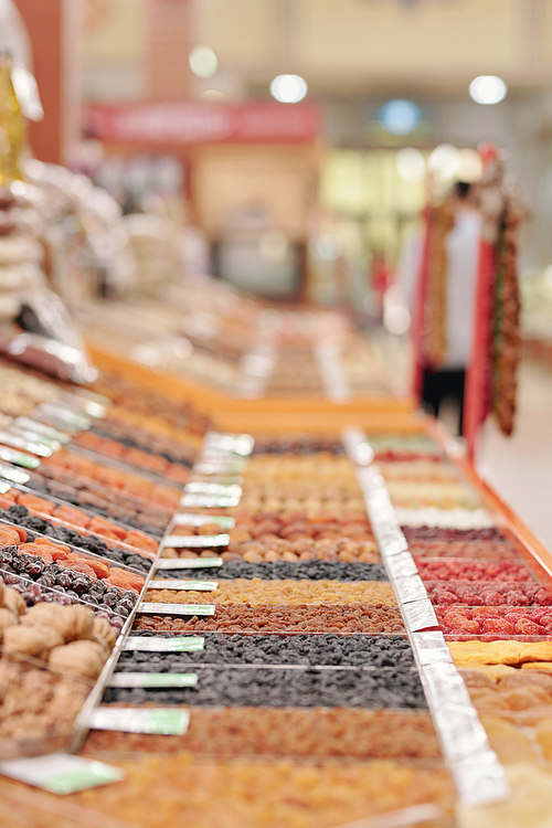 Dried fruits counter with various snacks at modern organic food market, quality products concept