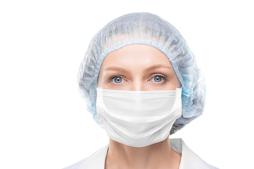 Portrait of lady doctor with blue eyes wearing face mask and surgical cap against white background