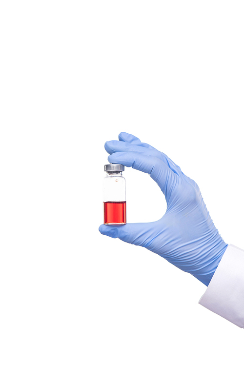 Close-up of unrecognizable doctor in surgical gloves holding medical bottle of red vaccine against white background