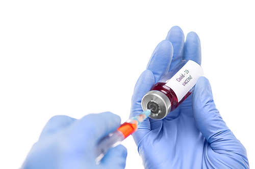 Close-up of nurse in surgical gloves filling syringe with vaccine against coronavirus, white background