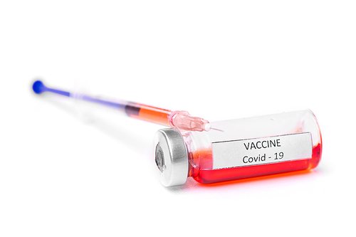 Close-up of bottle with red coronavirus vaccine and filled syringe on white background