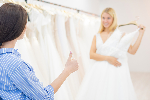 Unrecognizable woman approving her best friend's choice for wedding dress, horizontal shot
