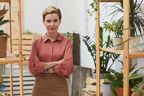 Waist up portrait of modern successful businesswoman  while posing in flower shop, copy space