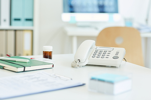 Background image of corded phone on empty table at workstation in clinic or hospital, copy space