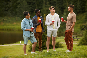 full length portrait of young men  beer and hatting during outdoor party in summer, copy space