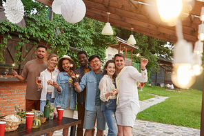 Multi-ethnic group of friends  and holding sparklers while enjoying Summer party outdoors, copy space
