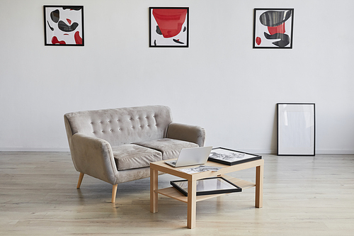 Background image of designer interior with couch and coffee table decorated by modern abstract paintings on wall, copy space