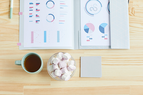 Top view background image of wooden table with business documents and snacks, home office concept, copy space