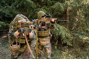 Focused army soldiers in camouflage shooting rifles while neutralizing enemy force