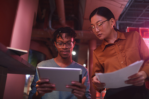 Low angle portrait of contemporary business team working on creative project in futuristic office interior