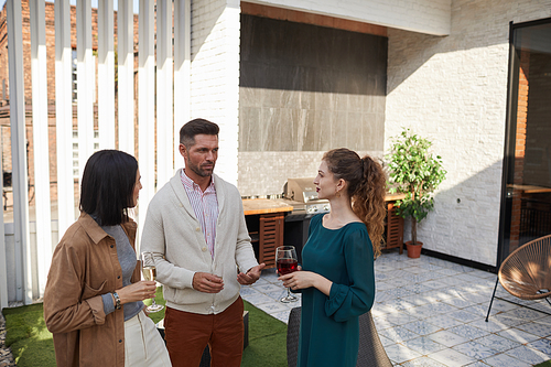 Waist up portrait of contemporary adult people chatting while standing at outdoor terrace during party, copy space