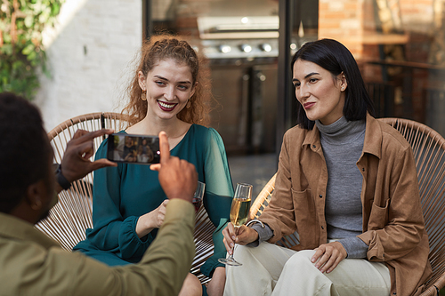 Portrait of two elegant women posing for photo and smiling at camera while enjoying outdoor party, copy space