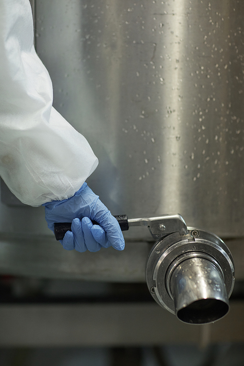 Close up of unrecognizable worker opening barrel tap at clean food production factory, copy space